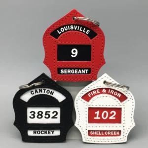 Three firefighter helmet keychains with numbers